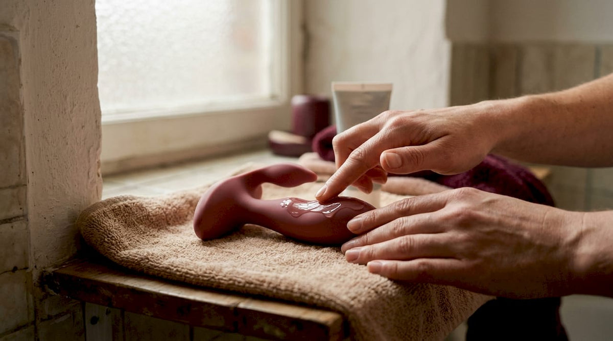 Hands applying lubricant to prostate massager