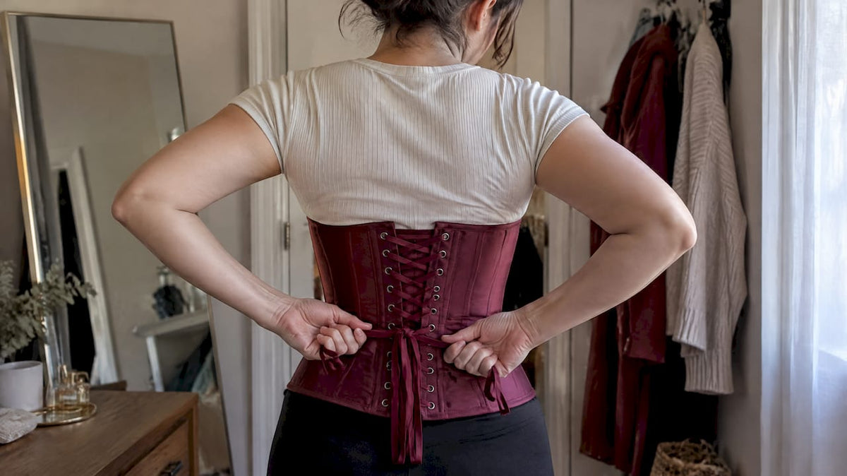Woman tightening corset laces by herself